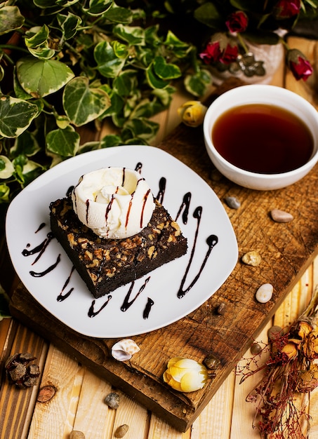 Free photo a slice of chocolate brownie with walnut and vanilla ice cream.