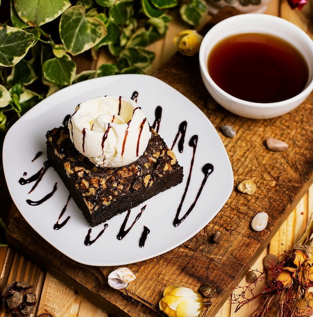 Free Photo a slice of chocolate brownie with walnut and vanilla ice cream   