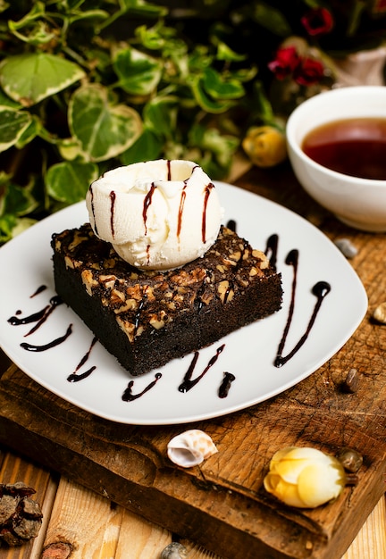 A slice of chocolate brownie with walnut and vanilla ice cream   