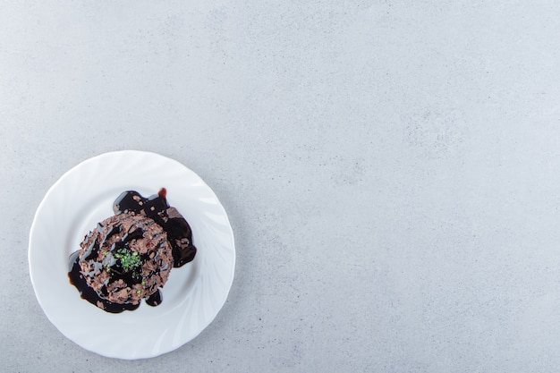 Slice of chocolate cake decorated with syrop on white plate. High quality photo