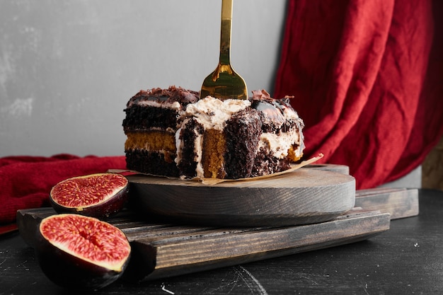 A slice of chocolate cheesecake on a wooden board. 