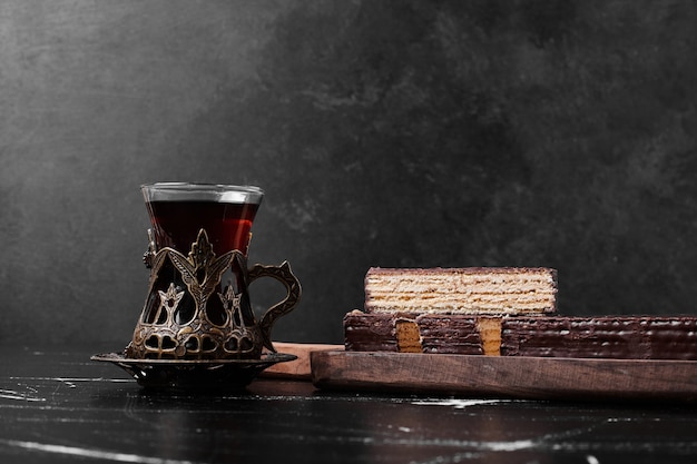 A slice fo cake with a glass of tea. 