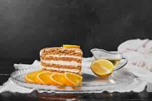 Free photo a slice of honey cake with orange slices.