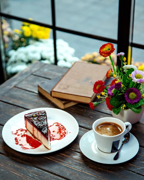 A slice of raspberry cheesecake served with espresso