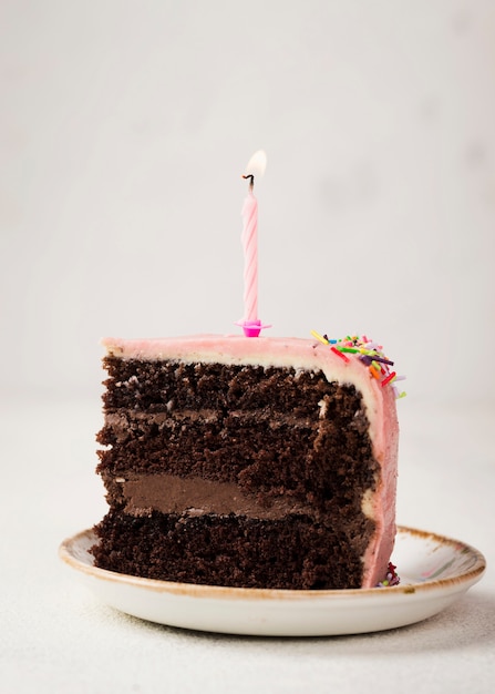 Free Photo slice of tasty cake with candle on top