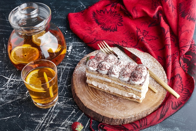 A slice of tiramisu cake with a glass of lemonade. 