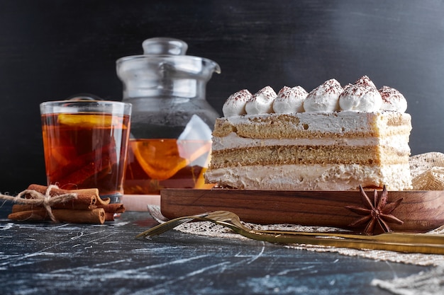 A slice of tiramisu with a glass of drink. 