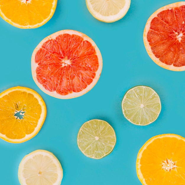 Free photo slice of various citrus fruits on blue surface