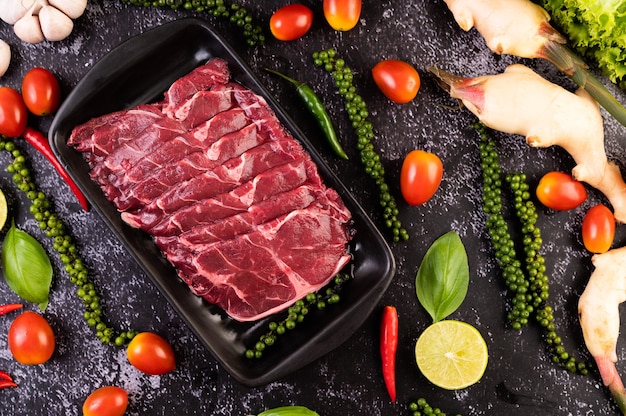 Sliced Ã¢ÂÂÃ¢ÂÂraw pork used for cooking with chili, tomato, basil, and fresh pepper seeds.