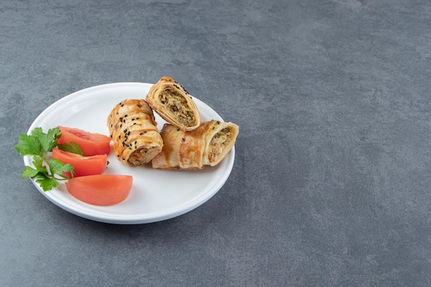 Free photo sliced braided bun stuffed with meat on white plate.