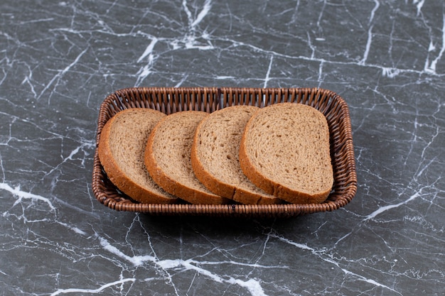 Sliced bread in the bread bowl , on the marble surface