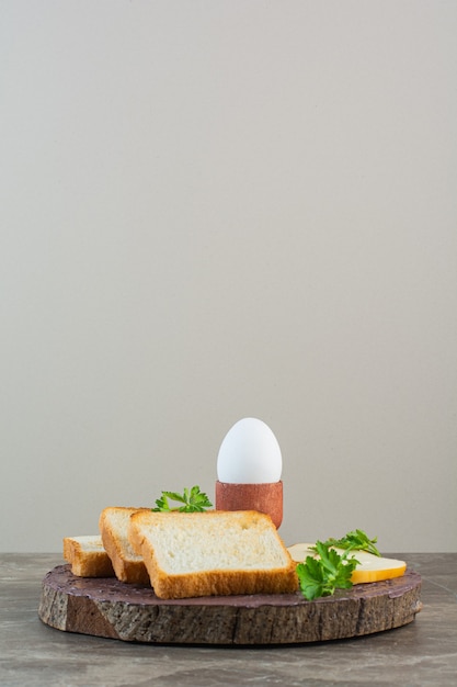 Free Photo sliced bread, cheese and boiled egg on a board , on the marble background.