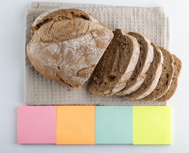 Sliced bread with colorful sticky notes side view on a white surface