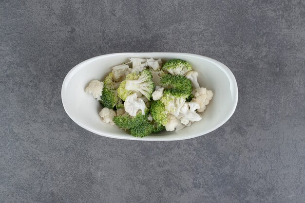 Sliced broccoli and cauliflower in white bowl. High quality photo