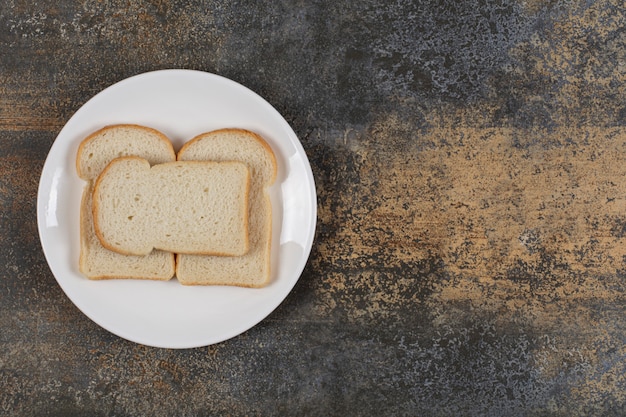 Free photo sliced brown bread on white plate.