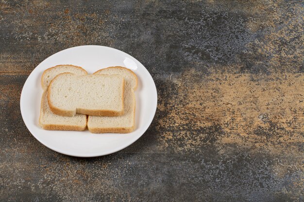 Sliced brown bread on white plate. 