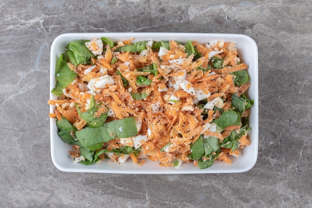 Sliced carrot salad on white plate.