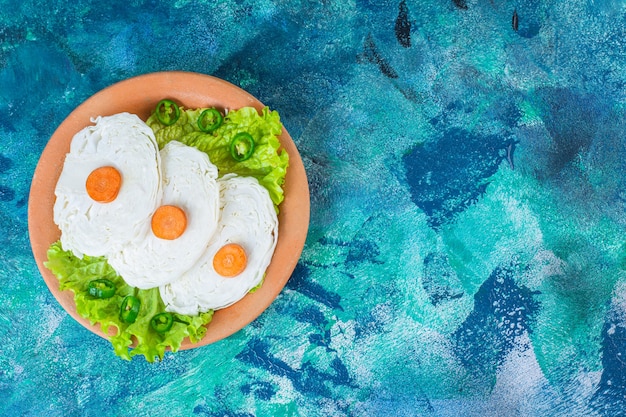 Free photo sliced carrots, cabbage and lettuce leaves on a plate