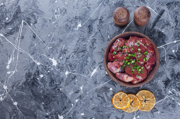 Sliced dried lemons and offal in a bowl on the blue surface