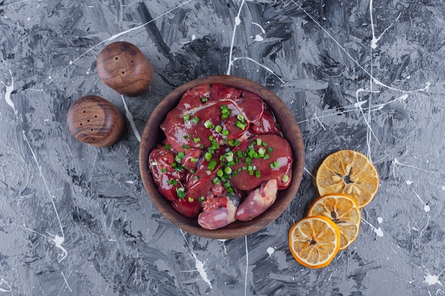 Free photo sliced dried lemons and offal in a bowl on the blue surface