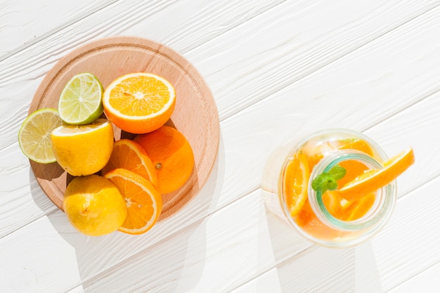 Free photo sliced fruit with bottle of lemonade