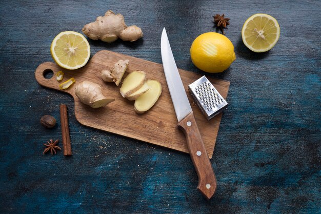 Sliced ginger on wooden board with lemon 