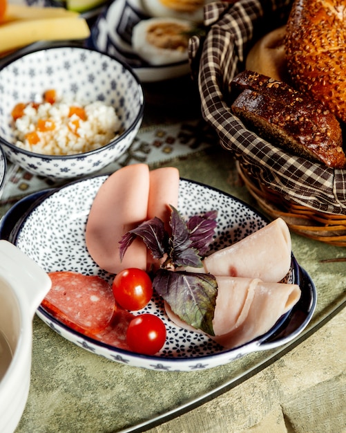 Sliced ham and sausage with bread basket