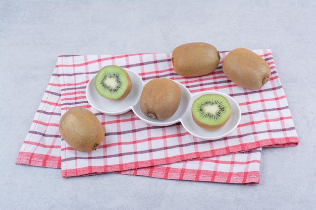 Free Photo a sliced kiwi in white plate on tablecloth. high quality photo