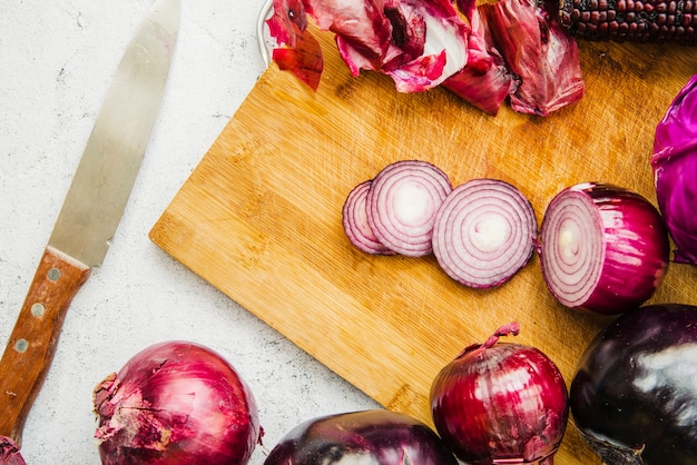 Free Photo sliced onion with vegetables on chopping board near knife