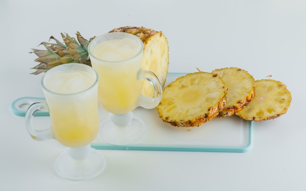 Sliced pineapple with juices on cutting board