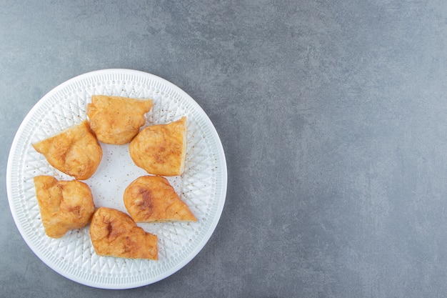 Free photo sliced piroshki with potatoes on white plate.