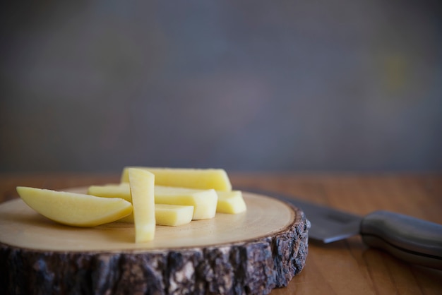 Sliced potato stick ready for making French fries - traditional food preparation concept