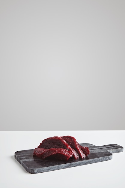 Free photo sliced premium raw whale meat steak on marble stone cutting board isolated on white table