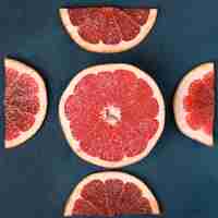 Free photo sliced red fresh grapefruit on blue.