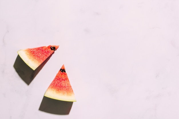 Free photo sliced red watermelon on pink surface