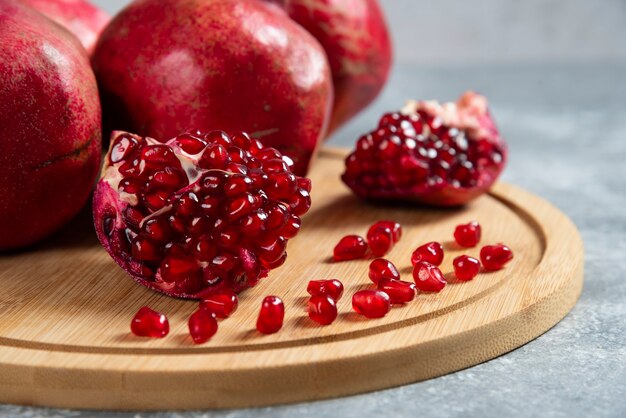 Sliced ripe pomegranate on a wooden board.