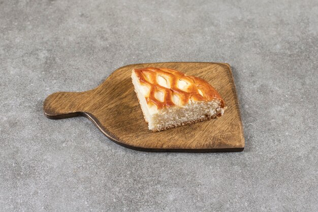 Sliced sweet bread on a cutting board, on the marble table. 