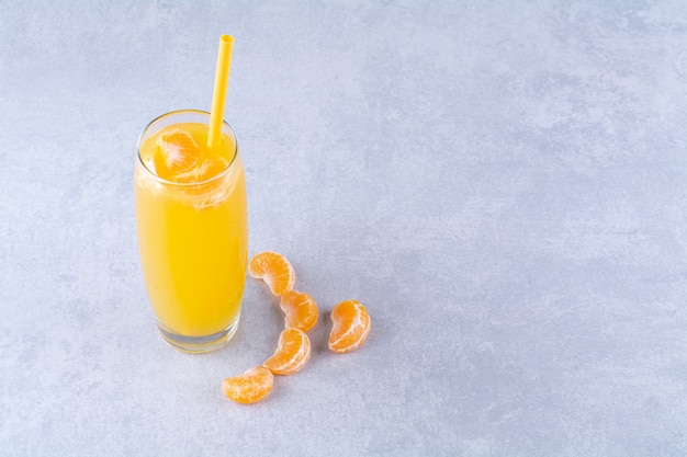 Sliced tangerine and a glass of juicy , on the marble background.