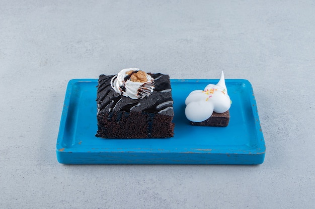 Free Photo sliced of tasty chocolate brownie with cream on blue plate. high quality photo