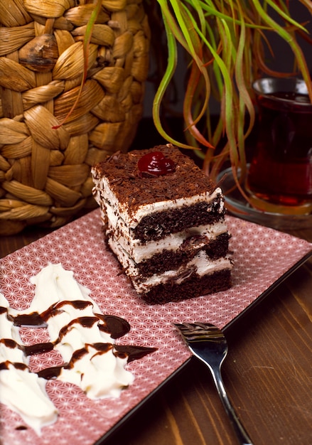 Sliced Tiramisu cake made of chocolate and white sponge. A piece of dessert on wooden boards.