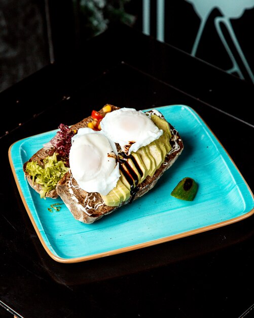 Sliced vegetables on black bread with sour cream