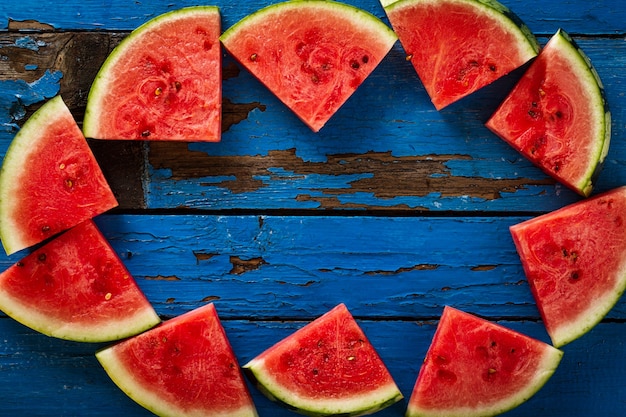 Sliced watermelon Top View. Many slices on an old rustic blue table. Side composition with copy space. Food Backrgound.