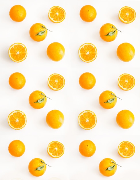 sliced and whole oranges on a light surface