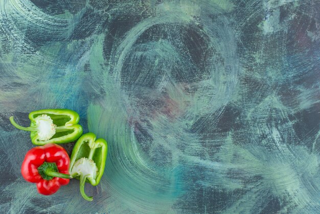 Sliced and whole sweet peppers , on the marble background. 