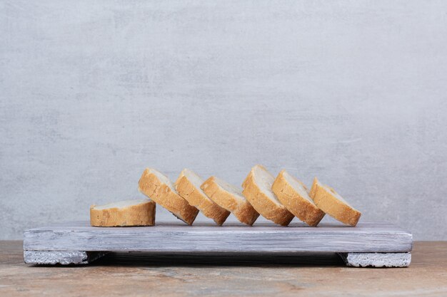 Slices of baguette bread on wooden board