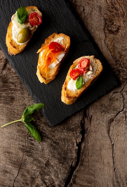 Slices of bruschetta on black wooden board