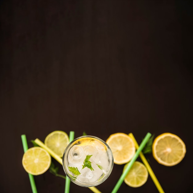 Free photo slices of citrus near glass of drink with ice