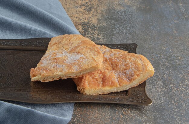 Slices of feseli bread on a small ornate tray on wooden .