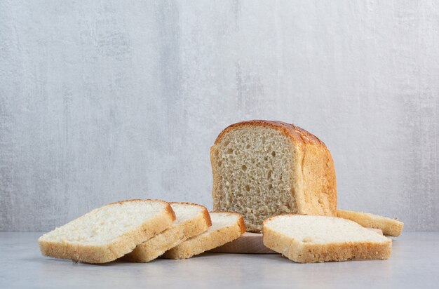 Slices of fresh bread on marble background. High quality photo