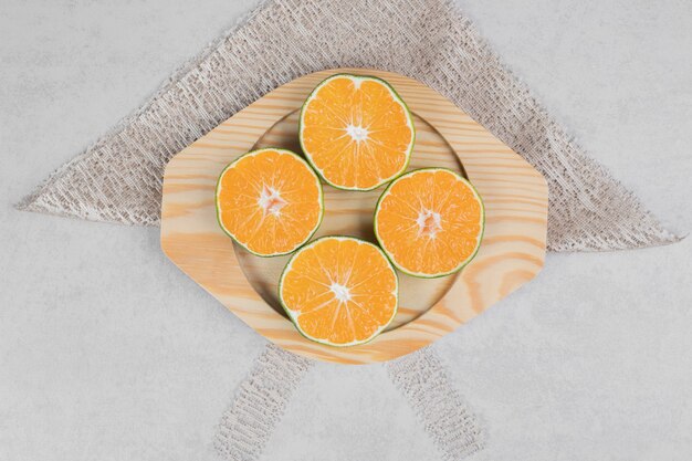 Slices of fresh tangerines on wooden plate. High quality photo